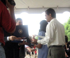 Candidate receives Naturalization Certificate; Kevin Gallagher of USCIS congratulates a new citizen - Photo by Duane Booth